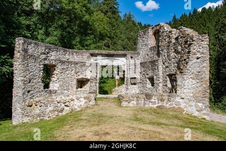 Vue arrière de la jeune femme debout à la porte de l'ancien fort de la ruine lors d'une journée ensoleillée d'été. Banque D'Images