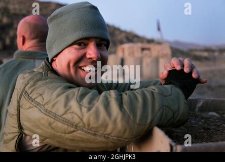 Le premier lieutenant Nathan Phillips de l'armée américaine, de Fayetteville, N.C., se dresse sur un mur de barrière et regarde les tirs d'artillerie de 155 mm frapper sur une colline voisine sur combat Outpost Cherkatah, province de Khowst, Afghanistan, le 26 novembre 2009. L'artillerie a été tirée par les forces américaines au cours d'un tir d'essai. Phillips est déployé avec la Compagnie D, 3e Bataillon, 509e Régiment d'infanterie. Banque D'Images