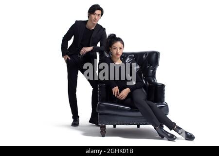 Un couple à la mode assis sur un canapé de luxe Banque D'Images