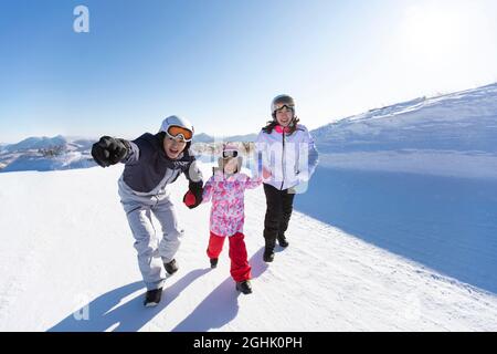 Une bonne petite famille se détendant dans la station de ski Banque D'Images