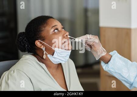 Femme laissant le médecin dans un gant de protection pour obtenir un écouvillon nasal pour l'envoyer au laboratoire pour le test Banque D'Images