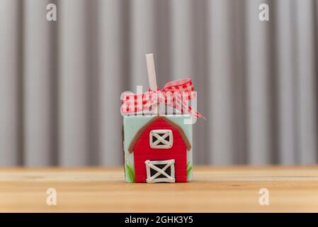 décoration en chocolat carré sur le thème de la ferme. Bonbons décorés de massepain en forme de grange rouge. Banque D'Images