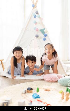 Enfants mignons jouant dans la tente Banque D'Images