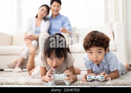 Mignon frère ou sœur jouant à un jeu vidéo à la maison Banque D'Images