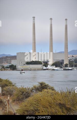 Les gens pêchent à l'entrée de Morro Bay, avec la centrale électrique désaffectée à l'arrière - bonne pêche pour les touristes, San Luis Obispo County, CA Banque D'Images