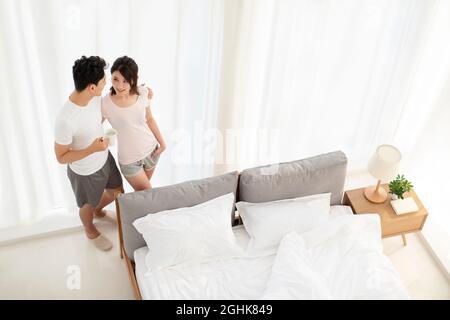 Happy young couple in bedroom Banque D'Images