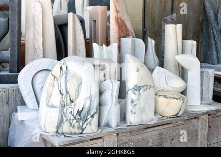 Assortiment de statues en marbre italien blanc abstrait Carrara exposées sur un banc dans un atelier pour la décoration intérieure et extérieure Banque D'Images