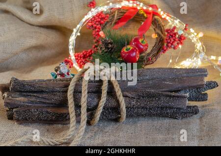 Composition festive avec gâteries pour chiens sur le sac. Estomac de bœuf séché. Tripe de bœuf de différentes tailles. Gâteries pour animaux de compagnie à croquer. Couronne de Noël à l'arrière Banque D'Images