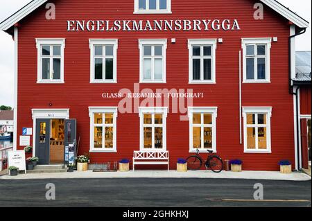 Façade rouge d'une boutique de souvenirs avec banc blanc dans les îles Lofoten, Norvège Banque D'Images