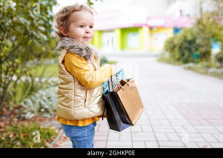 Vendredi noir. Réduction sur la vente. Journée shopping. Ensembles de garde d'enfants. Marque préférée des enfants. Fille avec sac de shopping. Achats et achats. Banque D'Images