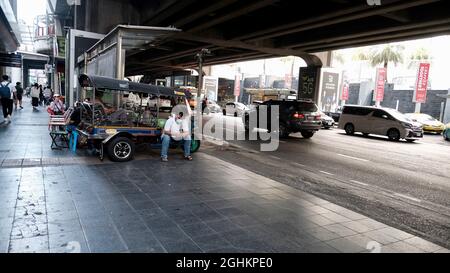 Tuk Tuk chauffeur assis attendant un client sous la station BTS Siam à Siam Square Bangkok Thaïlande pendant le confinement en cas de pandémie Banque D'Images