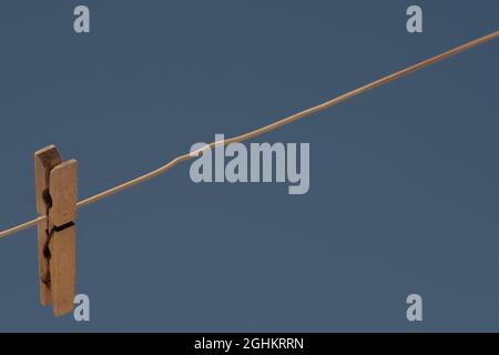 Vue d'une seule épingle à linge accrochée à une corde contre un ciel bleu Banque D'Images