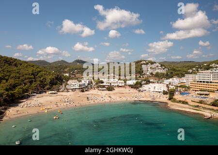 Photo aérienne de l'île espagnole d'Ibiza montrant le beau front de mer et les hôtels et les gens sur et la plage de Cala Llonga en été Banque D'Images