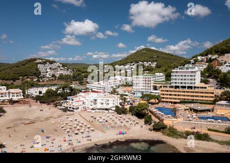 Photo aérienne de l'île espagnole d'Ibiza montrant le beau front de mer et les hôtels et les gens sur et la plage de Cala Llonga en été Banque D'Images