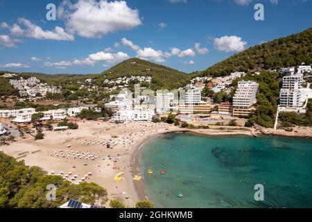 Photo aérienne de l'île espagnole d'Ibiza montrant le beau front de mer et les hôtels et les gens sur et la plage de Cala Llonga en été Banque D'Images