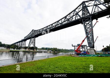 07 septembre 2021, Schleswig-Holstein, Osterrönfeld : une grue se dresse sur un chantier de construction sous le pont ferroviaire de Rendsburg. Cinq ans et demi après qu'il ait été endommagé, des travaux ont commencé sur l'installation d'un nouveau traversier flottant. Il est entré en collision avec un navire de mauvaise visibilité le 8 janvier 2016. Le ferry flottant historique a été tellement endommagé qu'il a dû être démantelé. Photo: Frank Molter/dpa Banque D'Images