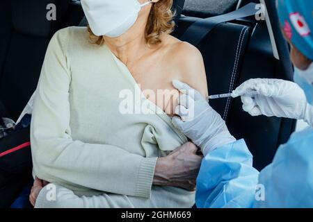 Une femme âgée recevant l'injection du vaccin coronavirus par une infirmière pour recevoir les anticorps, immuniser la population. Effets secondaires, personnes à risque, anticorps, nouvelle normale, covid-19 Banque D'Images