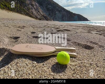 Matkot jeu grec de paddle Beach tennis avec balle et raquettes en bois avec carte de l'île de Lefkada, plage de Mylos. Équipements sportifs sur une plage de sable en Grèce Banque D'Images