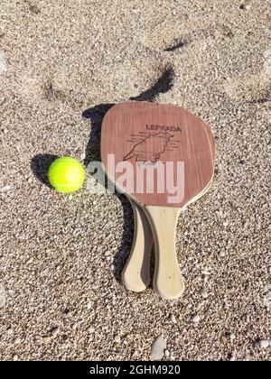 Matkot jeu grec de paddle Beach tennis avec balle et raquettes en bois avec carte de l'île de Lefkada, Grèce. Équipements sportifs sur une plage de sable en Grèce. Verti Banque D'Images