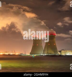 Rive avec centrale nucléaire Doel la nuit avec des nuages spectaculaires et de grands panaches de vapeur, Port d'Anvers, Belgique Banque D'Images