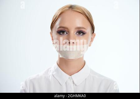 Prise de vue d'une jeune femme avec une bouche thermocollée isolée sur fond blanc Banque D'Images