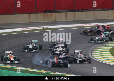 Sebastian Vettel (GER) Red Bull Racing RB8 survit à un accident avec Sergio Perez (MEX) Sauber C31 et Bruno Senna (BRA) Williams FW34 au début de la course. 25.11.2012. Championnat du monde de Formule 1, Rd 20, Grand Prix brésilien, Sao Paulo, Brésil, Jour de la course. Banque D'Images