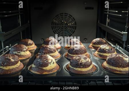 Processus de cuisson des muffins au chocolat au four, faits maison. Petits gâteaux sucrés au cacao cuits au four. Banque D'Images