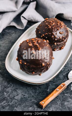 Dessert au chocolat avec crème, noix et biscuits sur l'assiette. Banque D'Images