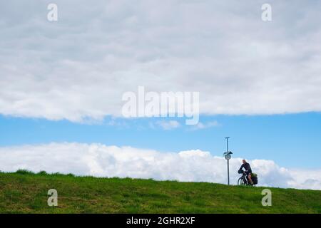 Cycliste sur la digue d'Elbe près de Vockfey, Basse-Saxe, Allemagne Banque D'Images