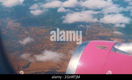 Une photo aérienne est prise par la fenêtre de l'avion. Le ciel nuageux pendant la journée. La ville peut être vue avec de la verdure et des montagnes. Benidorm, Espagne. Banque D'Images