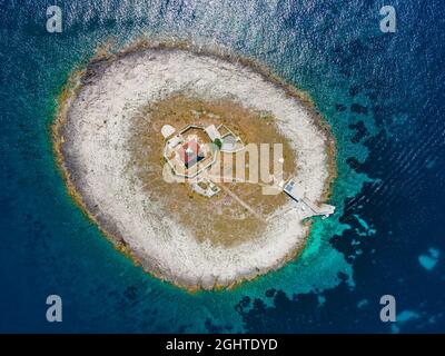 Vue aérienne de la petite île avec phare dans la mer Adriatique près de l'île de Hvar, Croatie faite avec drone. Vue de dessus. Destination de vacances d'été Banque D'Images