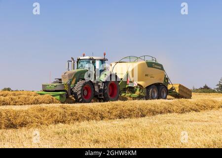 Tracteur et machine de mise en balles et mise en balles de paille dans un champ. Banque D'Images
