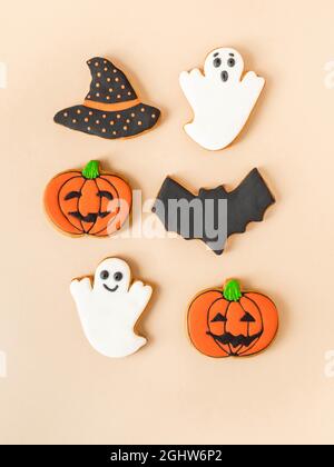 Divers biscuits au pain d'épice d'Halloween - Jack O'lanternes, fantômes, chauve-souris et chapeau noir sur fond beige. Concept Halloween. Vue de dessus. Banque D'Images