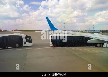 Aile d'avion et bus spécial pour déplacer les passagers d'un avion à l'autre terminal. Banque D'Images