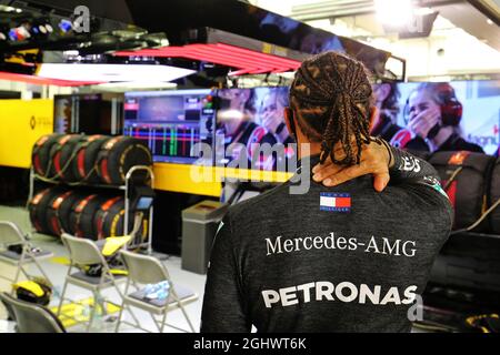 Lewis Hamilton (GBR) Mercedes AMG F1 dans les fosses pendant que la course est arrêtée regarde un replay de l'accident subi par Romain Grosjean (FRA) Haas F1 Team au début de la course. 29.11.2020. Championnat du monde de Formule 1, Rd 15, Grand Prix de Bahreïn, Sakhir, Bahreïn, Jour de la course. Le crédit photo doit être lu : images XPB/Press Association. Banque D'Images