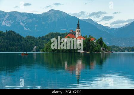 Lac de Bled vue de l'île avec église Assomption de Marie sur le beau lac avec bateau dans les Alpes Juliennes, Slovénie. Destination du voyage Banque D'Images