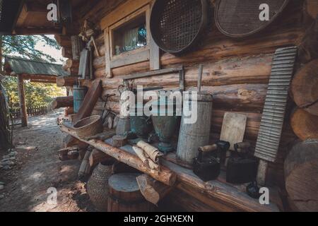 Articles de maison rétro sur un banc en bois près d'un mur en bois. Articles de ménage anciens de paysan. Banque D'Images