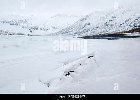 La neige couvrait les montagnes et brisait la glace sur le lac gelé Hraunsfjardavaatn dans la région de Berserkjahraun Lava Field pendant l'hiver sur le Snæfellsnesnes p Banque D'Images