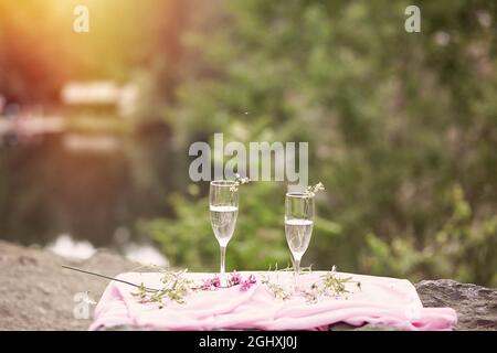 Bel automne. Champagne avec fleurs sauvages à l'extérieur. Pique-nique photo sur la nature avec lumière du soleil. Concept de célébration de la vie et de la solitude. Verres avec ch Banque D'Images