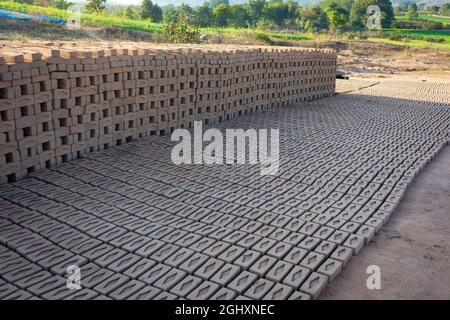 Les briques faites à la main de l'argile humide et de la boue sont conservées pour sécher avant le processus de combustion. Production traditionnelle de briques d'argile en Inde. Banque D'Images