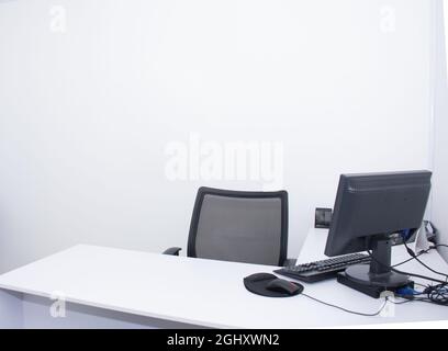 Bureau vide avec écran d'ordinateur dans un bureau blanc Banque D'Images