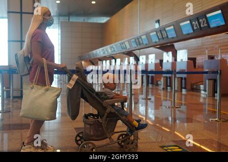 Mère et fils vont à la carte d'information à l'aéroport Banque D'Images