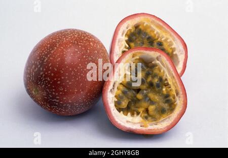 IMAGE DE STUDIO D'UN FRUIT DE LA PASSION ENTIER ET DIVISÉ EN DEUX SUR FOND BLANC. Banque D'Images