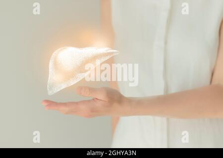 Patiente non reconnaissable en vêtements blancs, foie de mouchetée mis en évidence dans les mains. Concept des problèmes du système digestif humain. Banque D'Images