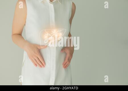 Patiente non reconnaissable en vêtements blancs, vésicule biliaire en surbrillance dans les mains. Concept des problèmes du système digestif humain. Banque D'Images