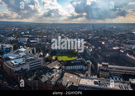 Vue aérienne sur les gratte-ciel de Dublin avec stade, terrain de jeu et bâtiments résidentiels et commerciaux sous un ciel nuageux au coucher du soleil Banque D'Images