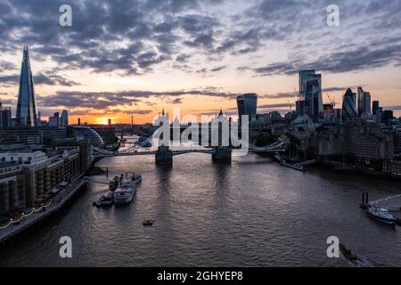 Plan d'établissement du célèbre Tower Bridge au-dessus de l'océan entouré de bâtiments et de gratte-ciels sous un lever de soleil nuageux le matin Banque D'Images