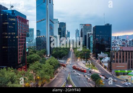 Vue aérienne des gratte-ciels financiers avec bus et voiture en mouvement dans la rue pendant la journée à Mexico sous ciel bleu ciel nuageux Banque D'Images