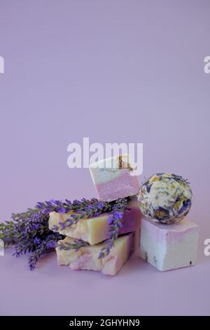 Lavande bombes et savon de bain, fleurs de lavande sur un fond pourpre.Spa et aromathérapie. Cosmétiques biologiques à base de plantes avec lavande.Beauté et Banque D'Images