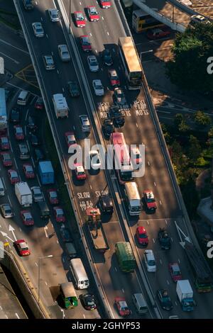 Les taxis et autres véhicules sur Connaught Road passent en plein soleil, à la lumière d'un bâtiment de grande hauteur, depuis le toit de 2ifc, sur l'île de Hong Kong Banque D'Images